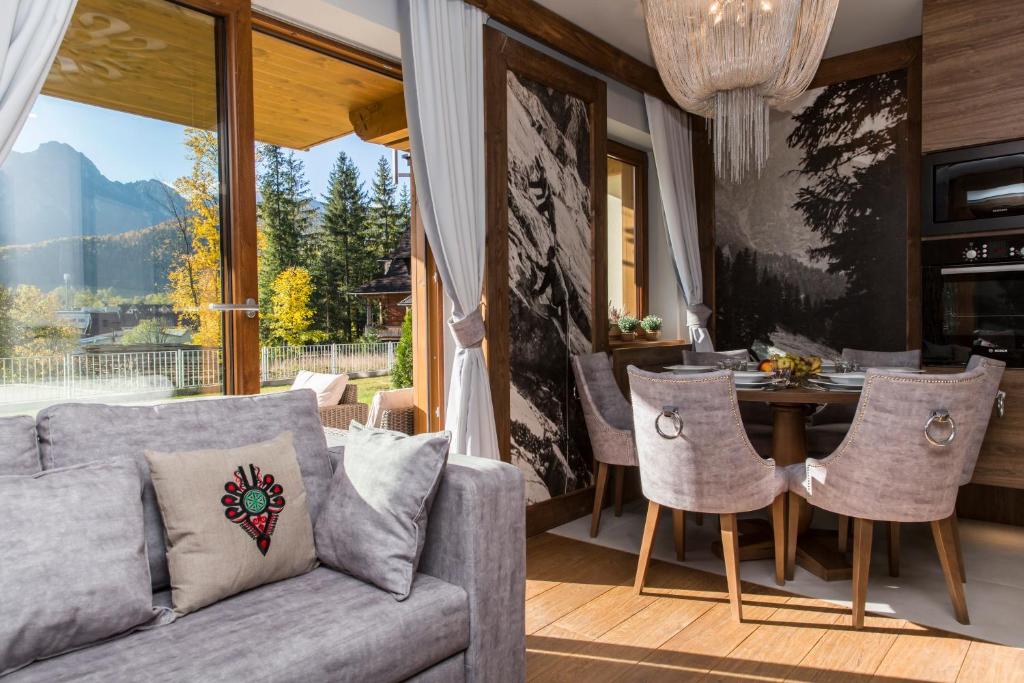 salon z kanapą i stołem w obiekcie Aspen Ski Szymaszkowa w Zakopanem