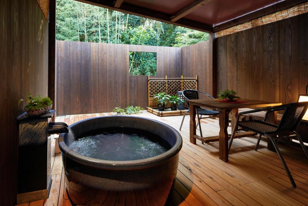 eine große Badewanne auf einer Terrasse mit einem Tisch in der Unterkunft Kiyomizu Inishie-an in Kyoto
