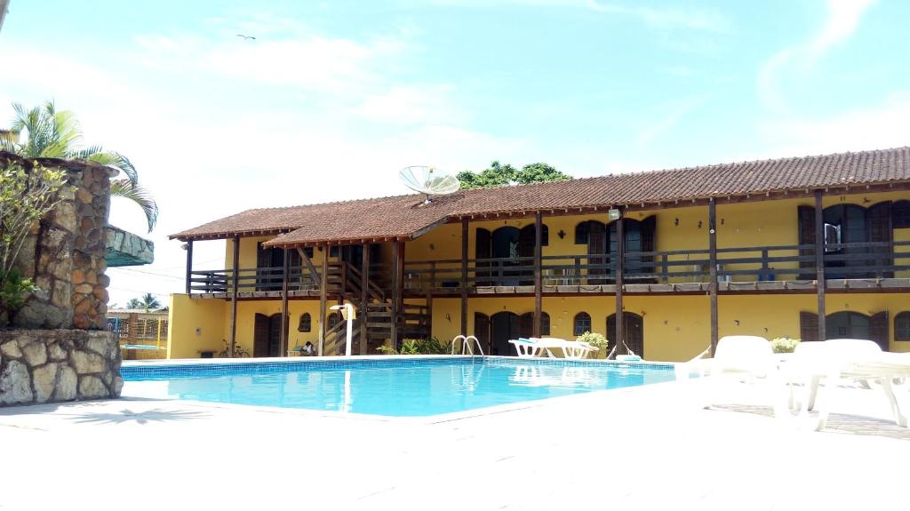 a resort with a swimming pool in front of a building at Sonhos Meu Pousada in Boracéia