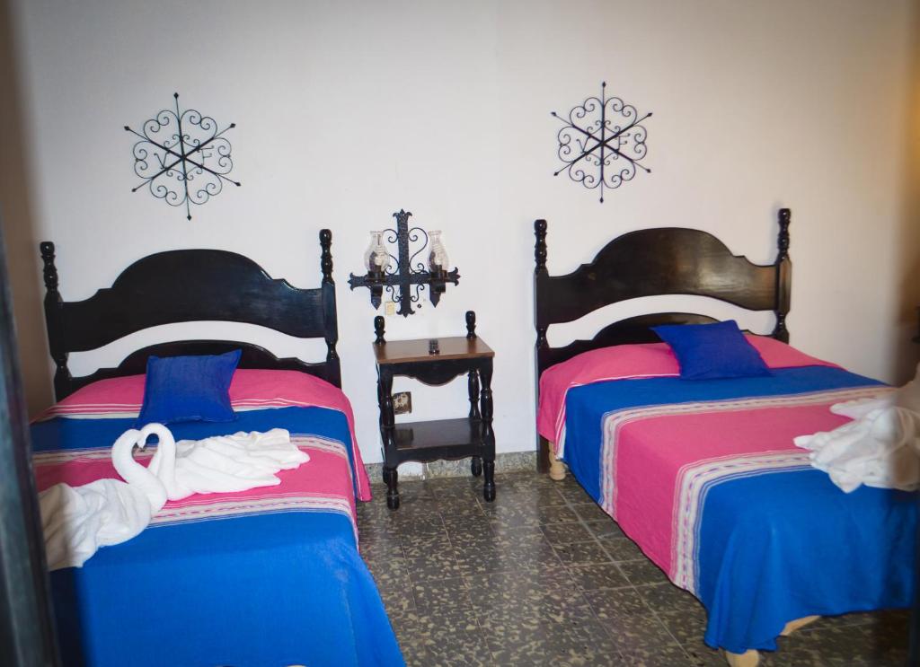 Postel nebo postele na pokoji v ubytování Hotel Villa de Flores
