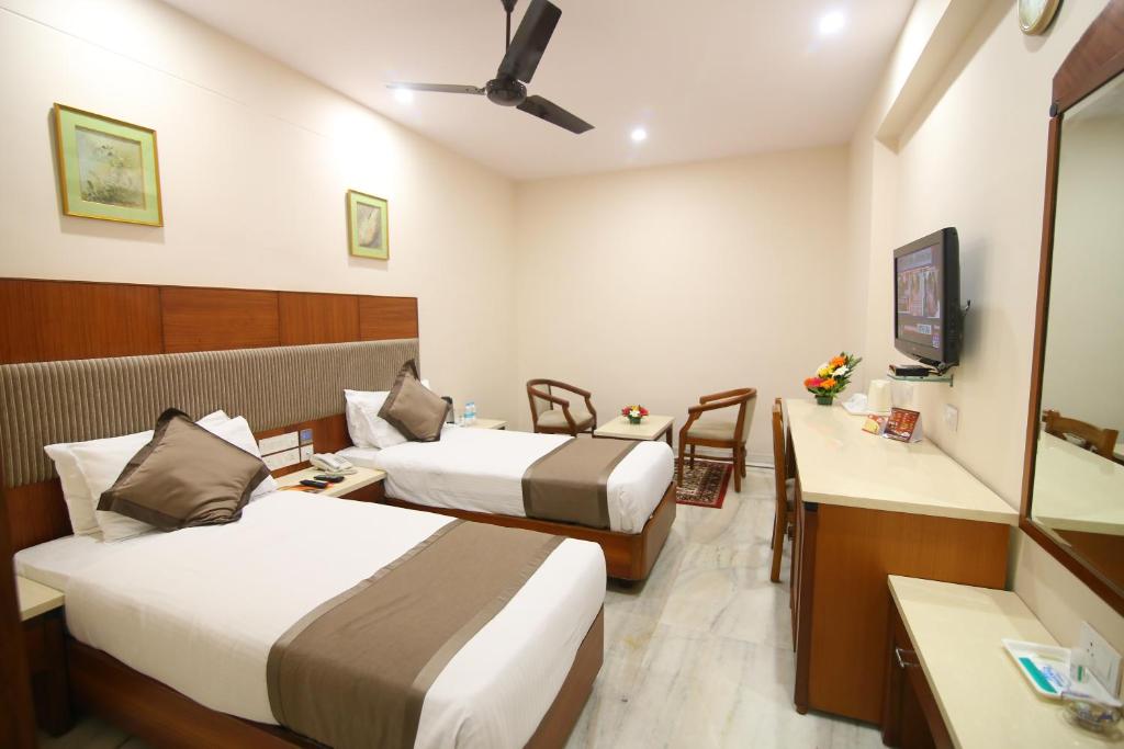 a hotel room with two beds and a tv at Daspalla Executive Court in Visakhapatnam