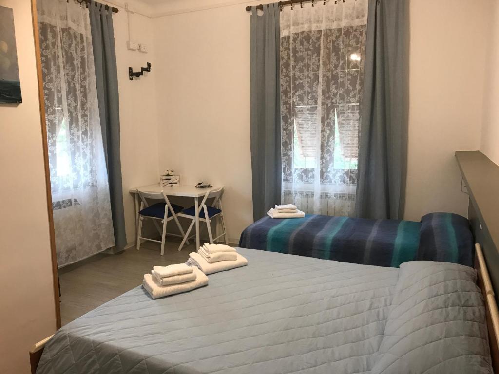 a bedroom with two beds and a table in the window at Albergo Chiara in Savignone