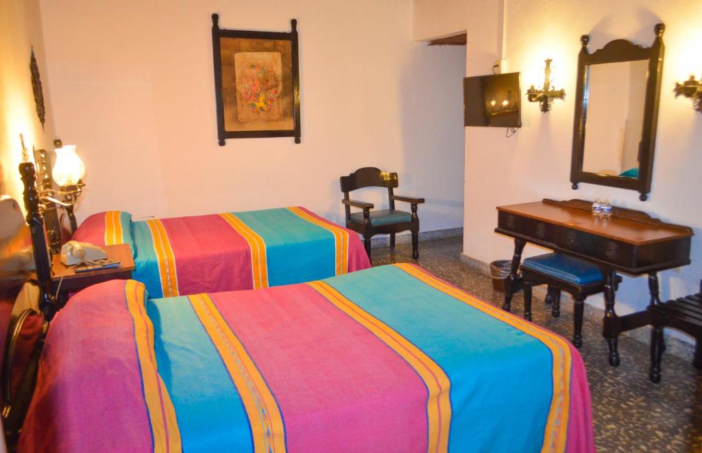 Postel nebo postele na pokoji v ubytování Hotel Villa de Flores