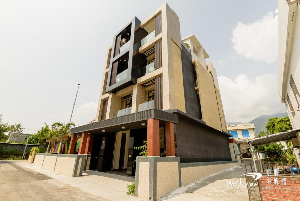 un bâtiment à la façade noire et blanche dans l'établissement Dulan Pearl Hill Homestay, à Donghe