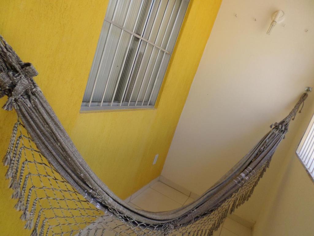 a hanging hammock in a room with a window at Casa para temporada in Prado