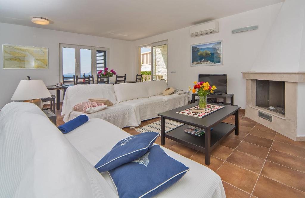 ein Wohnzimmer mit weißen Möbeln und einem Kamin in der Unterkunft I Sassi Bianchi - East Villa in Cavtat