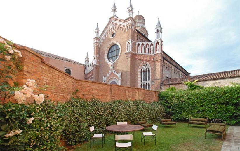 een tafel en stoelen voor een gebouw bij Casa Contarini in Venetië