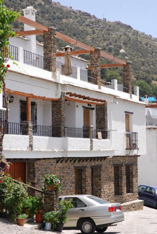 布维翁alojamiento rural la ermita bubion的停在建筑物前的汽车