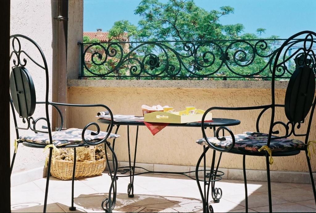 - Balcón con mesa y 2 sillas en B&B Porto Romano, en Olbia