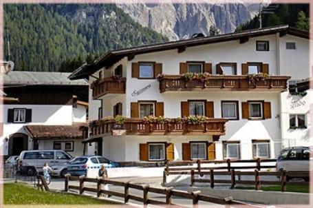a large building with cars parked in front of it at Garni Sayonara in Selva di Val Gardena