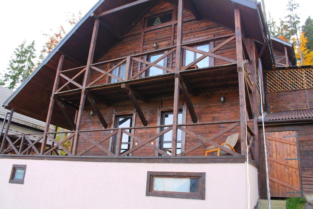 a large wooden house with windows on the side of it at Szlachta Cottage in Bukovel