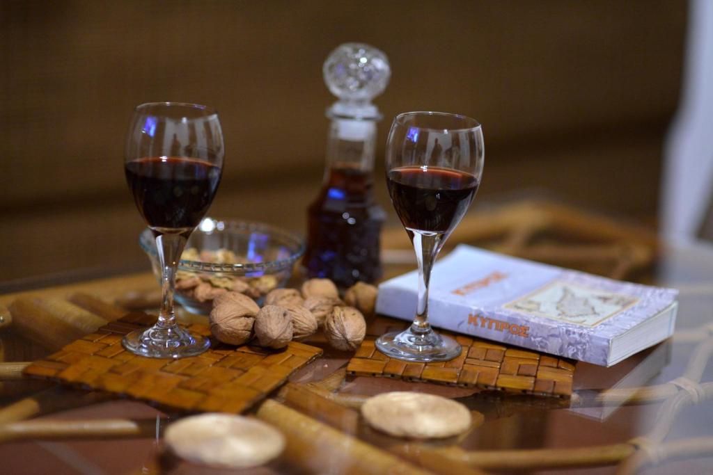 deux verres de vin rouge assis sur une table dans l'établissement Arhontiko Askas Mansion, à Askas