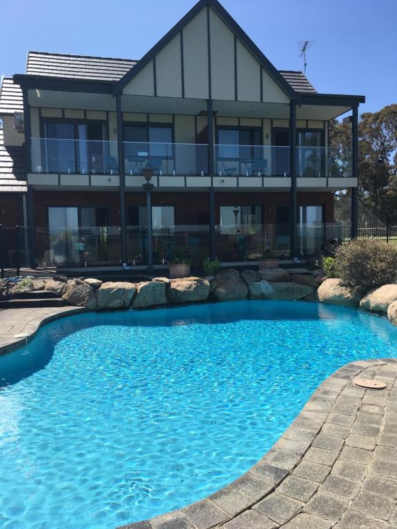 a house with a swimming pool in front of a house at The View on Grossmans in Torquay