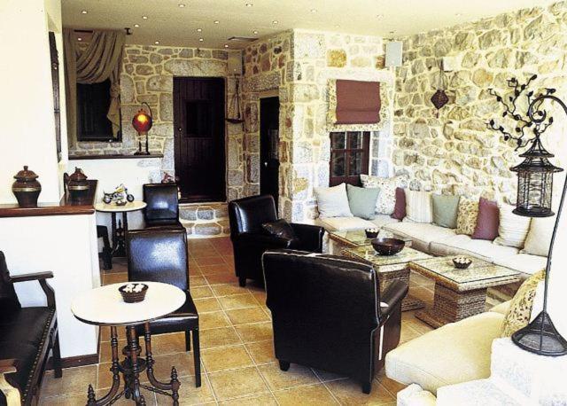 a living room filled with furniture and a stone wall at Katafigi in Pyrgos Dirou