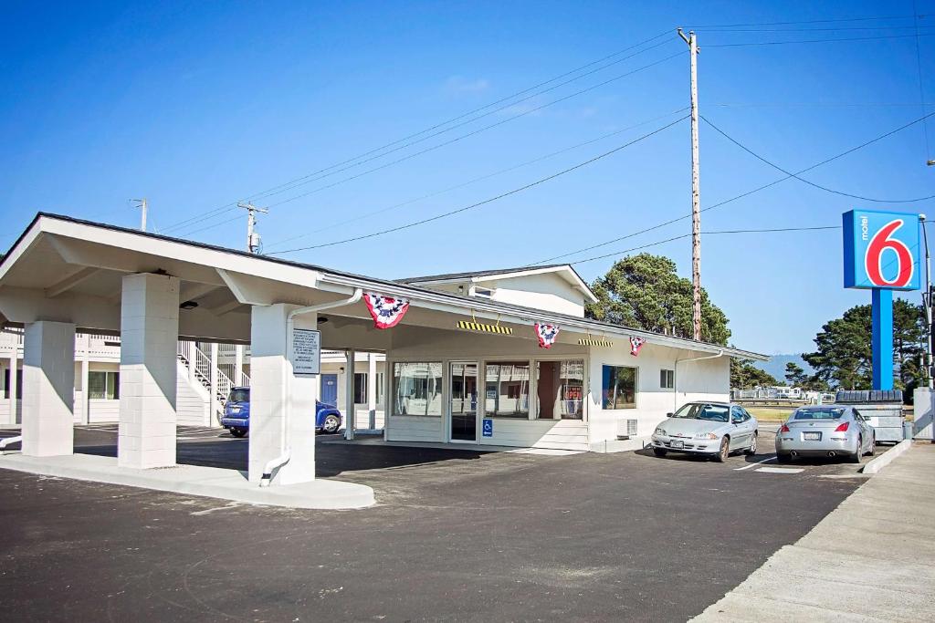 um posto de gasolina com carros estacionados num parque de estacionamento em Motel 6-Crescent City, CA em Crescent City