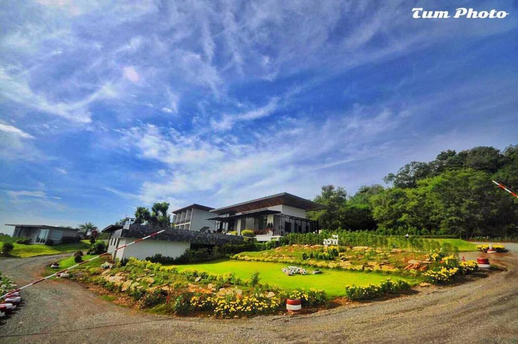 uma casa com um jardim em frente em Phurapee Pakchong em Ban Lam Thong Lang