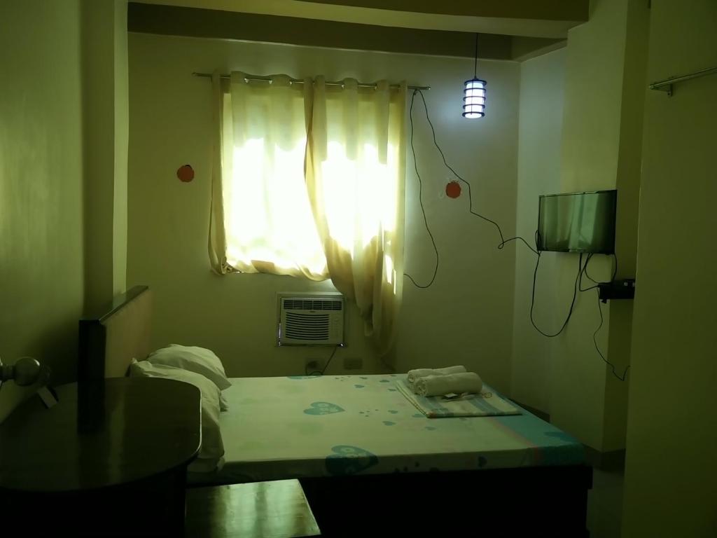 a room with a bed and a window with a light at AAM Transient and Guest House in Manila