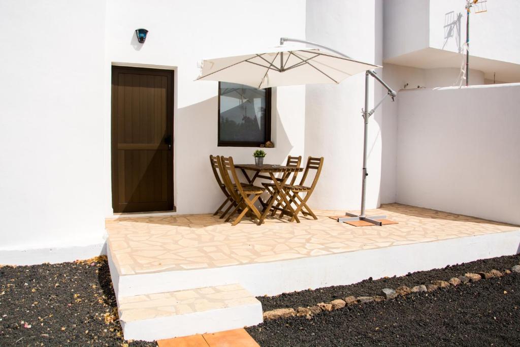 a patio with a table and an umbrella at Casa Maui in La Oliva