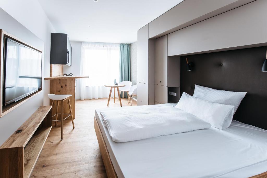 een hotelkamer met een bed en een televisie bij Felsen8 in Heidenheim an der Brenz