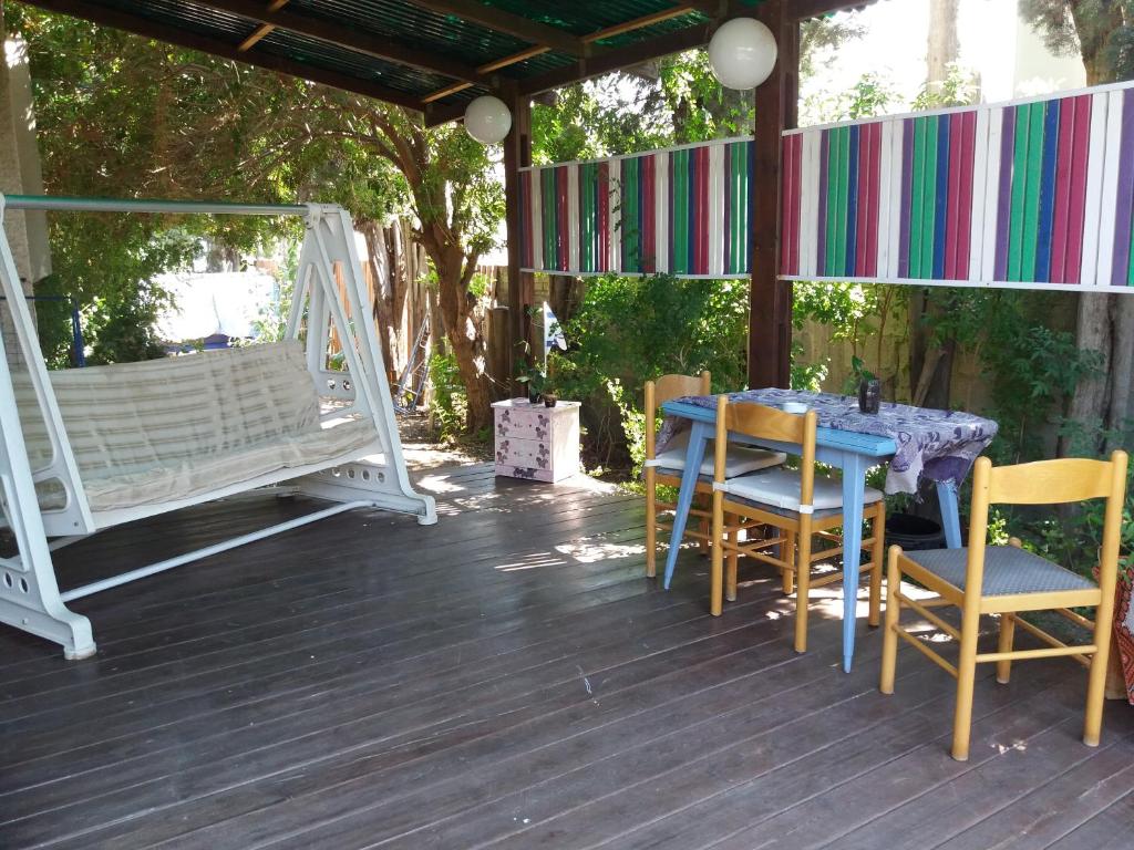 a blue table and chairs on a deck with a swing at Zipi Orhan in Acre