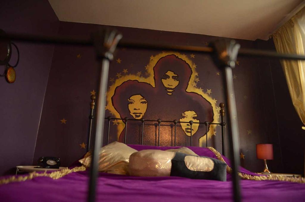 a bedroom with a bed with a painting on the wall at Hotel Pelirocco in Brighton & Hove