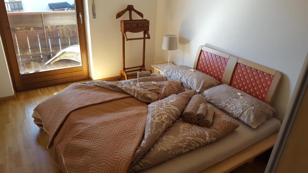 a bedroom with a large bed with pillows at SonnenApartment in Lana