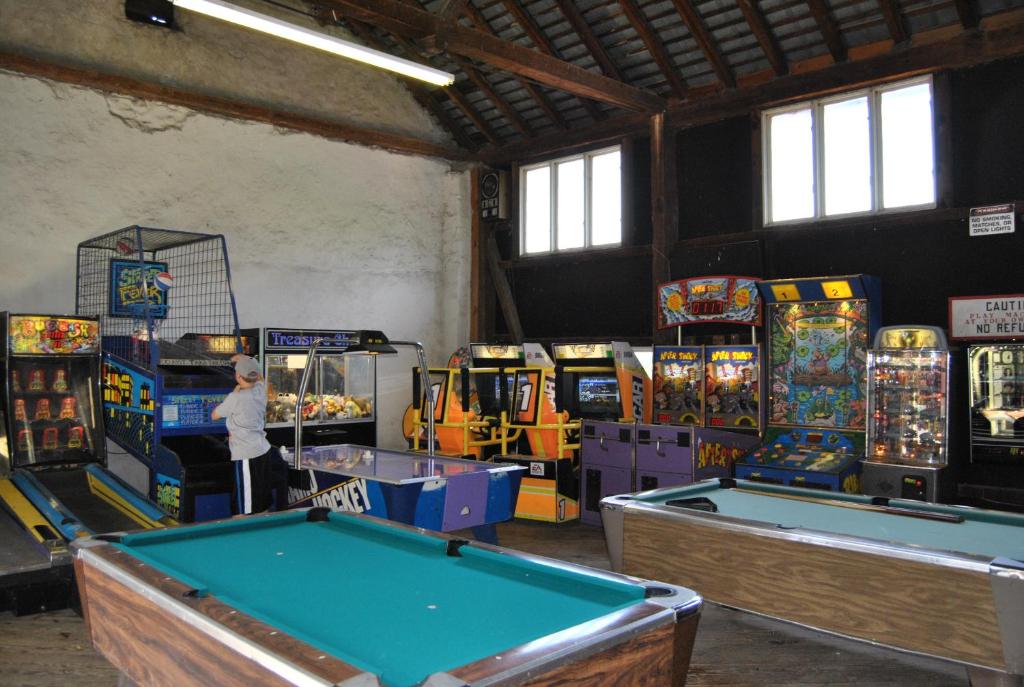 a room with several arcade games and pool tables at Robin Hill Camping Resort Premium Cottage 1 in Lenhartsville