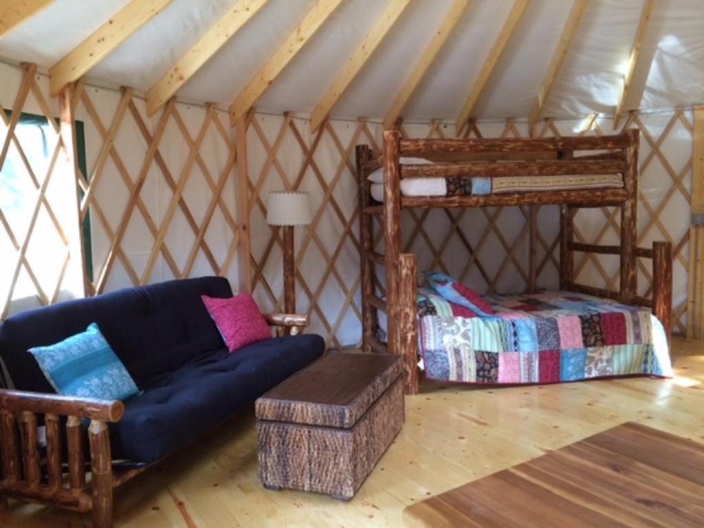 Habitación con sofá y cama en yurta en Circle M Camping Resort 24 ft. Yurt 2, en Lancaster