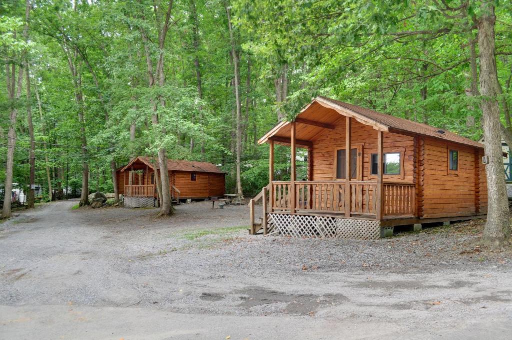 uma grande cabana de madeira na floresta com árvores em Sun Valley Campground Cottage 4 em Maple Grove Park