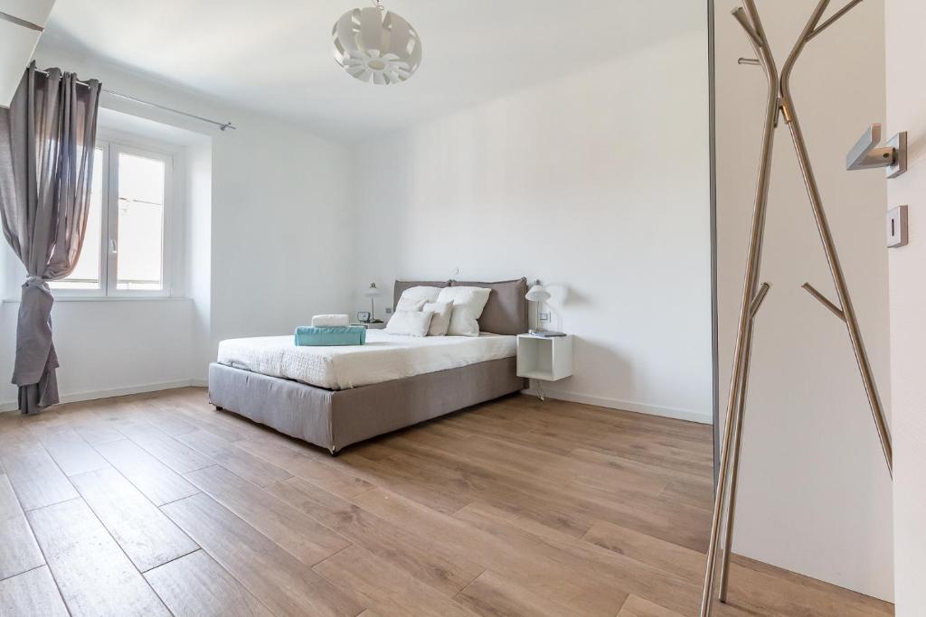 1 dormitorio blanco con 1 cama y suelo de madera en Alessia's Flat - Sarpi 3, en Milán