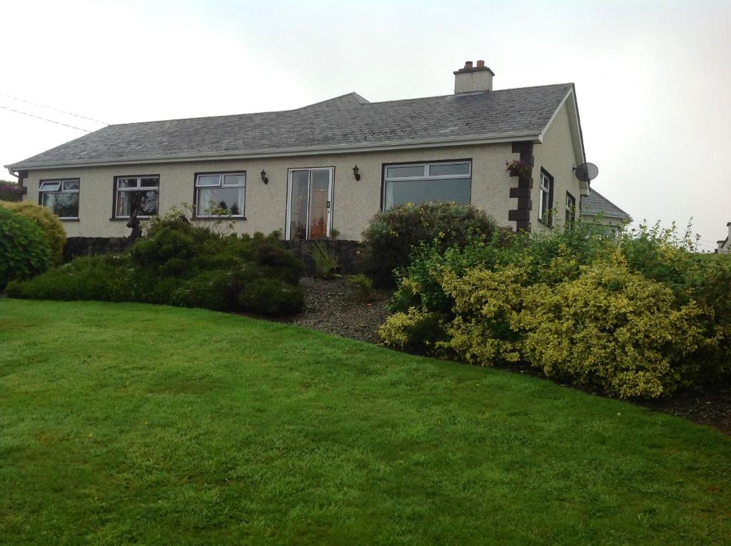 uma casa com um relvado verde em frente em The Rock Equestrian Farm B&B em Bailieborough