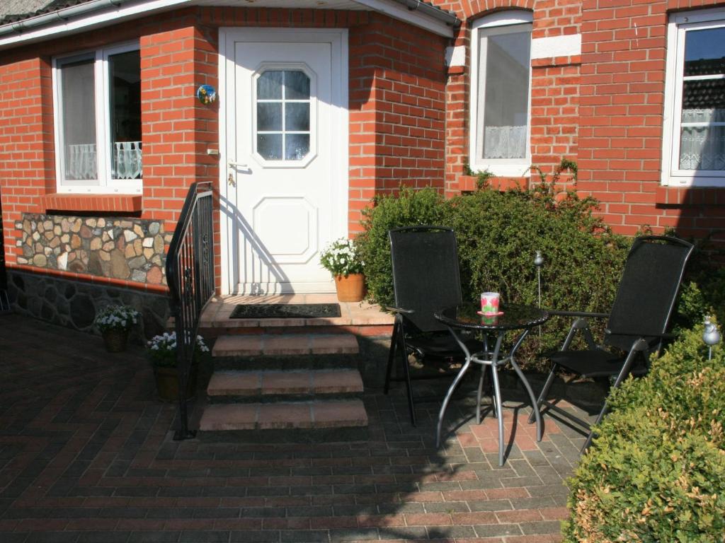 a brick house with a white door and a table at Cozy Apartment in Satow Kuhlungsborn and Doberan with garden in Satow