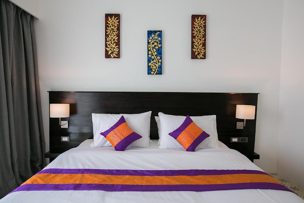 um quarto com uma cama com três fotografias na parede em SakSukSmile Resort em Sukhothai