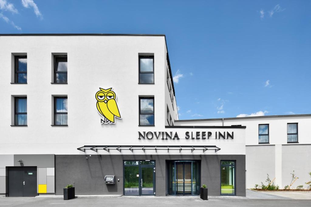 ein weißes Gebäude mit einem novia sleep inn Schild darauf in der Unterkunft Novina Sleep Inn Herzogenaurach in Herzogenaurach