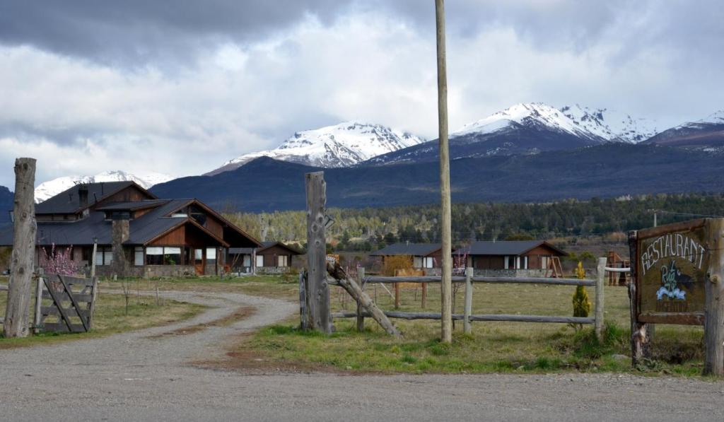 une clôture avec un panneau devant une montagne dans l'établissement Ruta 71, à Trevelín