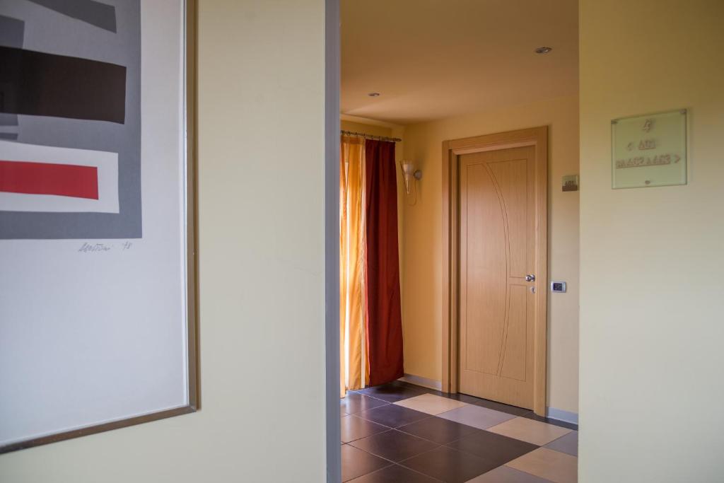 a room with a hallway with a door and a tile floor at Hotel Mediterraneo in Livorno