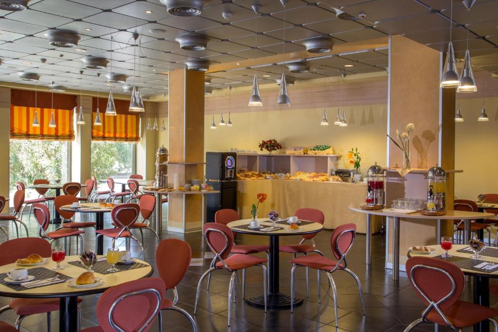 a restaurant with tables and chairs and a counter at Hotel Mediterraneo in Livorno
