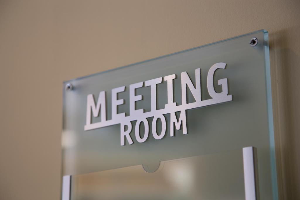 a meeting room sign hanging on a wall at Hotel Mediterraneo in Livorno