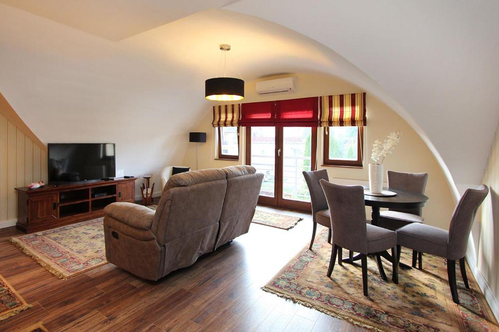 a living room with a couch and a table and chairs at Good Luck Apartment in Hévíz