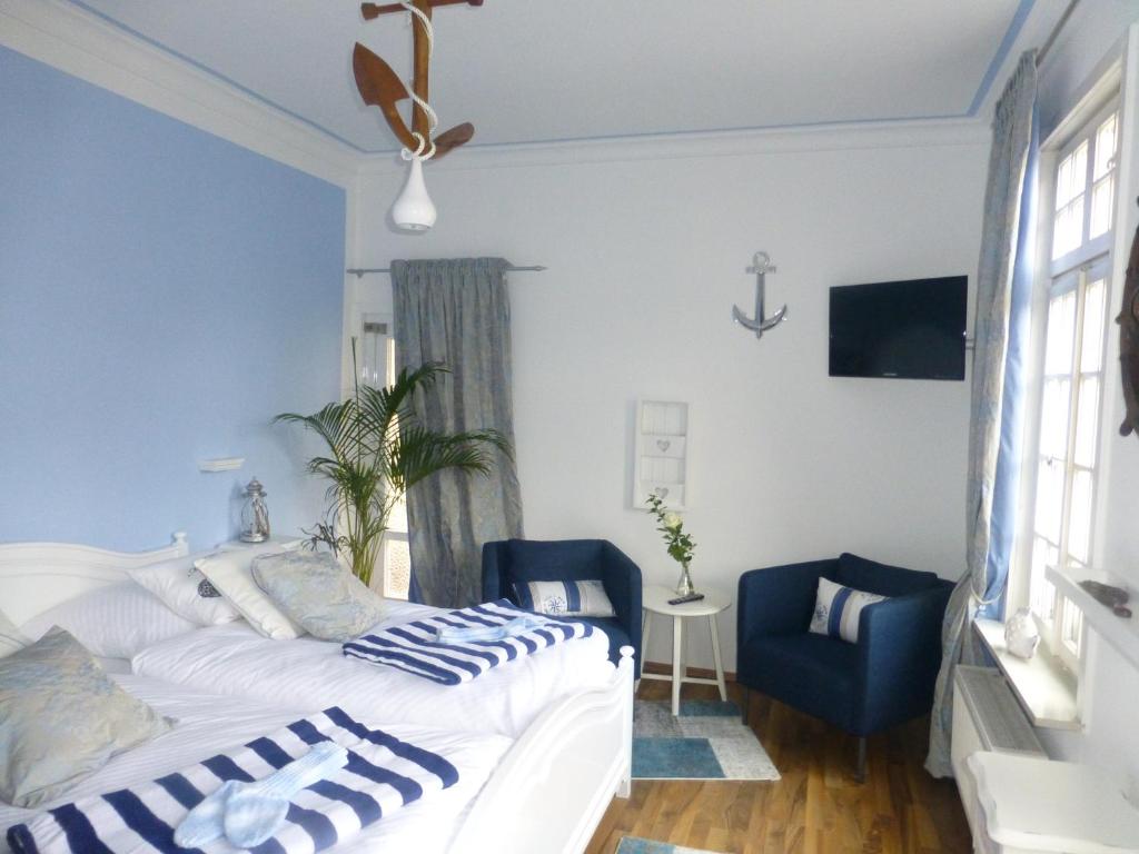 a bedroom with a bed and a blue chair at Pension Historisches Wirtshaus an der Lahn in Lahnstein