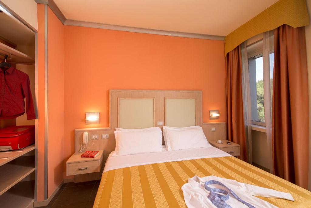 a bedroom with a bed with an orange wall at Hotel Mediterraneo in Livorno