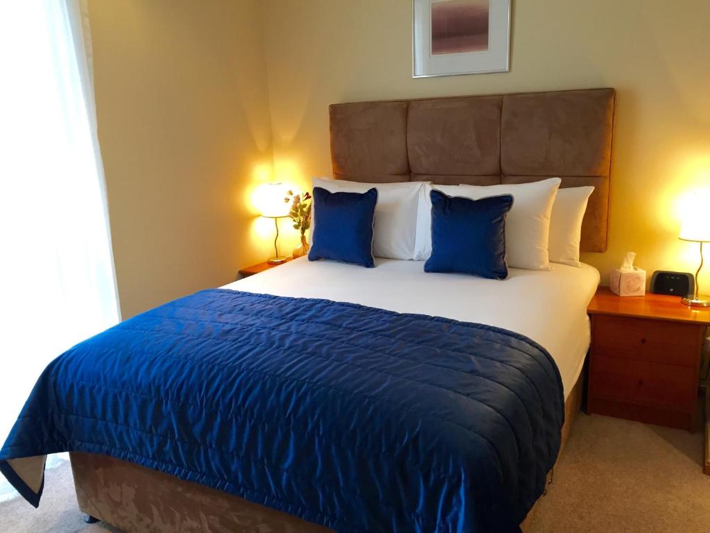 um quarto com uma cama grande e almofadas azuis em Rochester Apartment em Londres