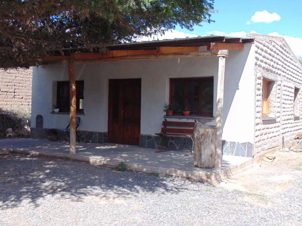 a small house with a bench in front of it at El Churqui in Humahuaca