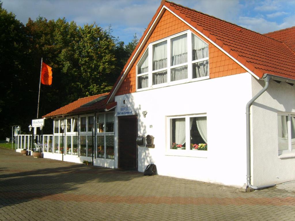 a white building with an orange roof at Hotel-Garni "Hof von Hannover" in Wittmund