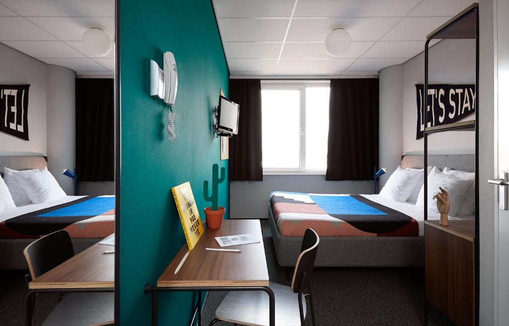 a room with two beds and a table and chairs at The Social Hub Amsterdam West in Amsterdam
