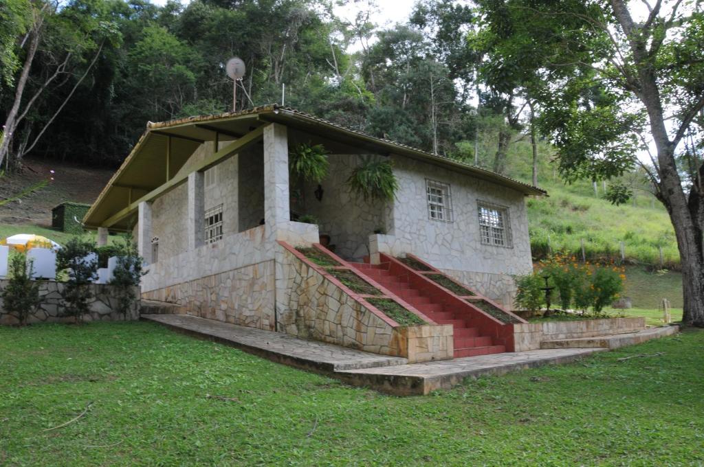 a small building with a staircase in a yard at Canto das Estrelas in Secretário