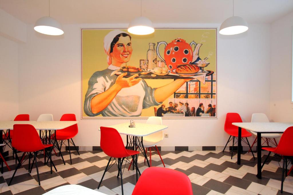 a restaurant with a painting of a woman holding a plate of food at Hotel Katyusha in Moscow