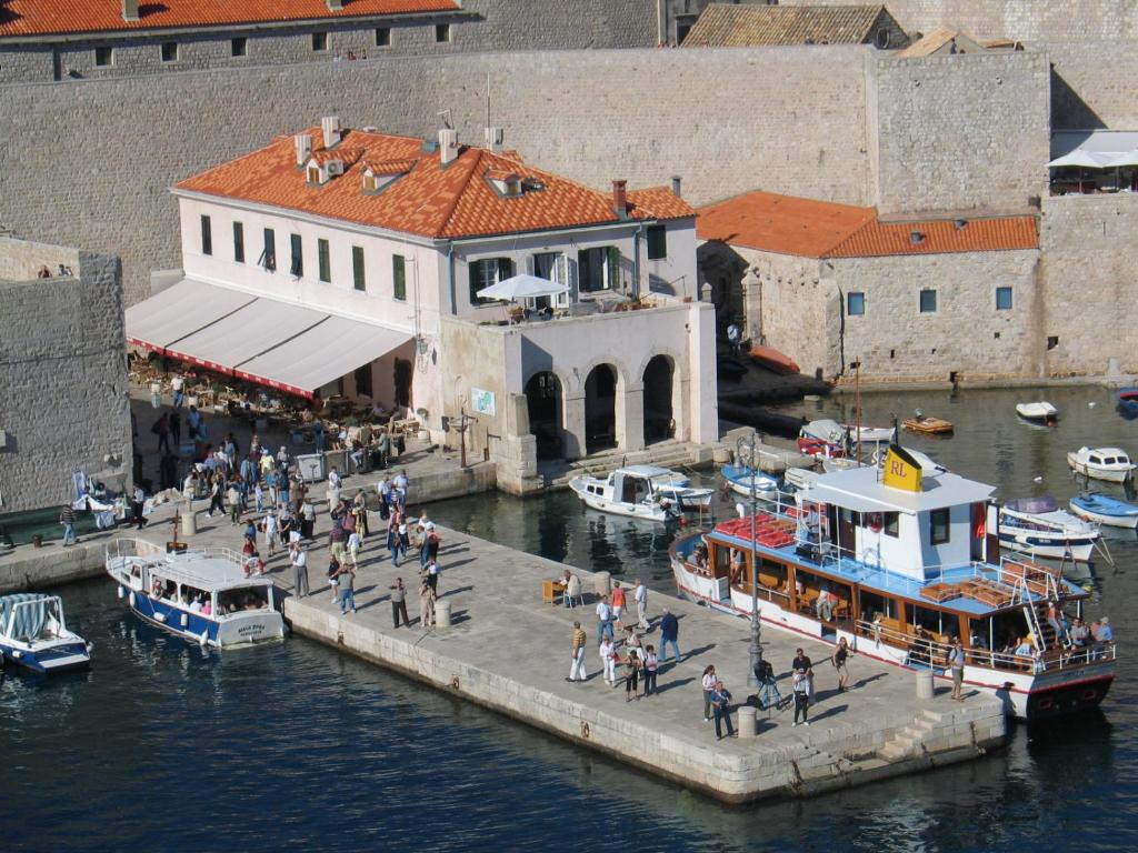 a group of people walking around a dock with boats at Old Town Port Apartments in Dubrovnik