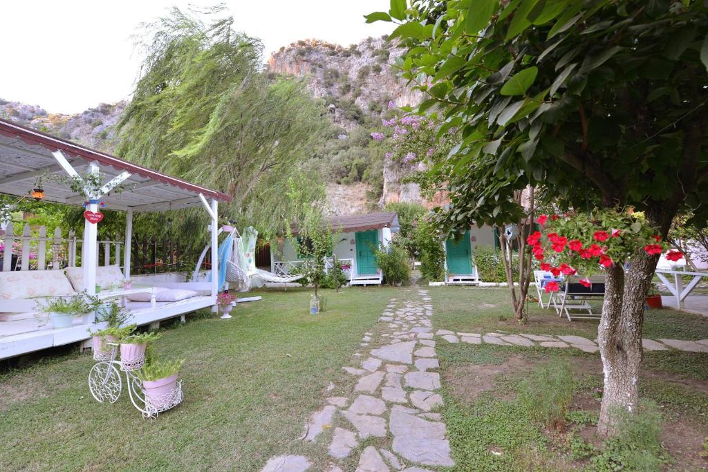 a garden with a stone walkway next to a house at Narcicegi Hotel in Cıralı