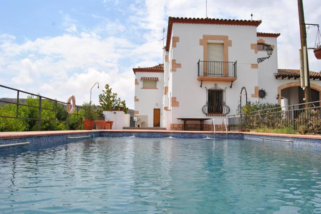 a villa with a swimming pool in front of a house at Sol Blanc in Alguaire